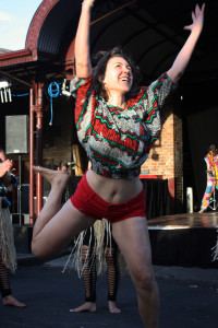 woman from audience with arms raised, big smile on her face (dancing)