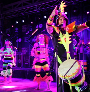 dancers posing for photo with bright fluro costumes