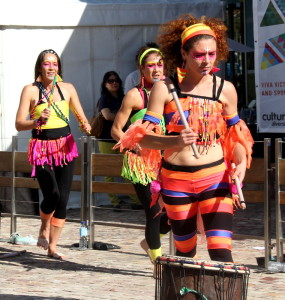 Two djembe players in foreground and dundun players in background